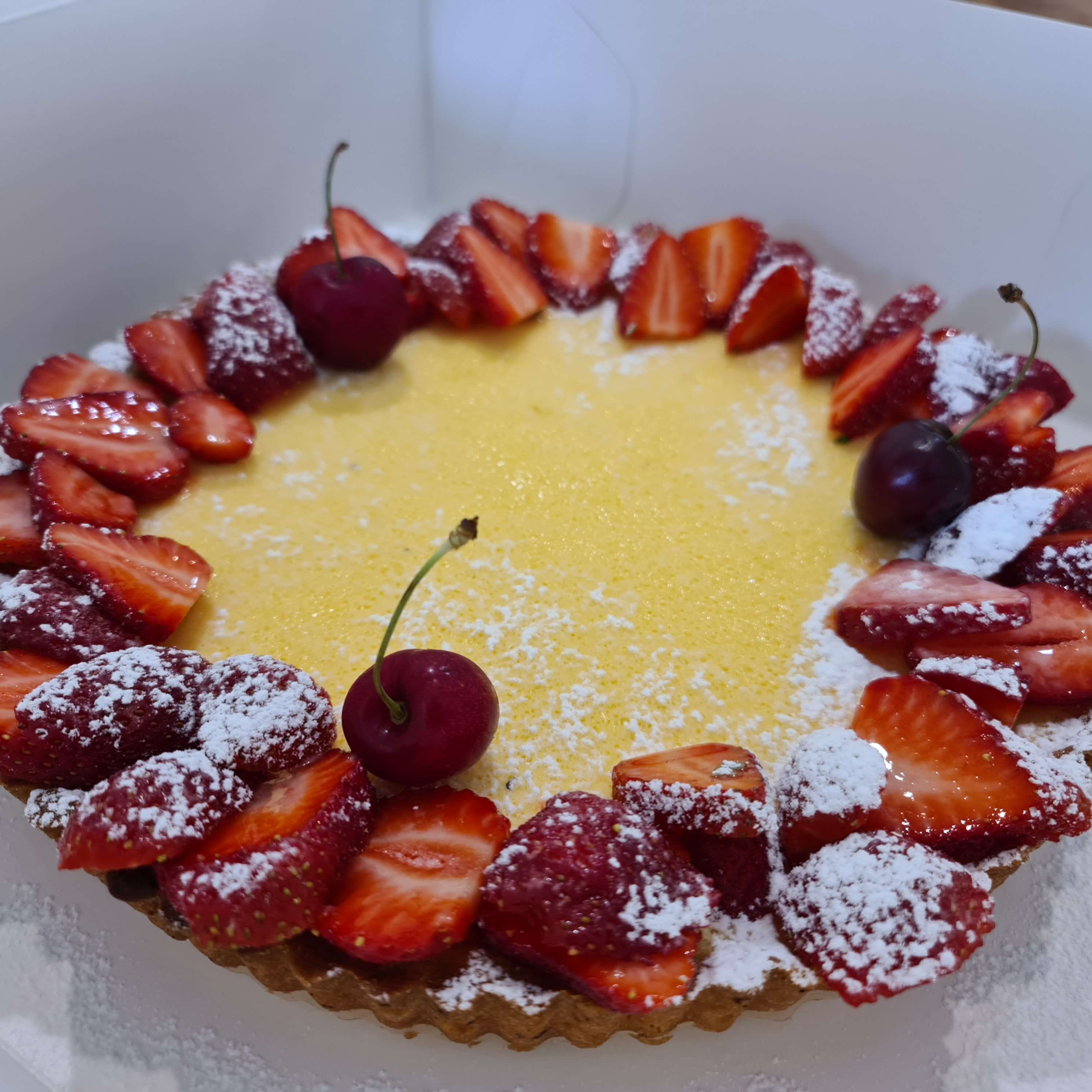 Citron tart topped with fresh strawberries and cherries
